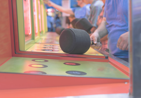 Whac-a-Mole arcade game with colorful moles popping up from holes as a player uses a mallet to hit them back down, symbolizing the repetitive and reactive nature of dealing with multiple unexpected challenges